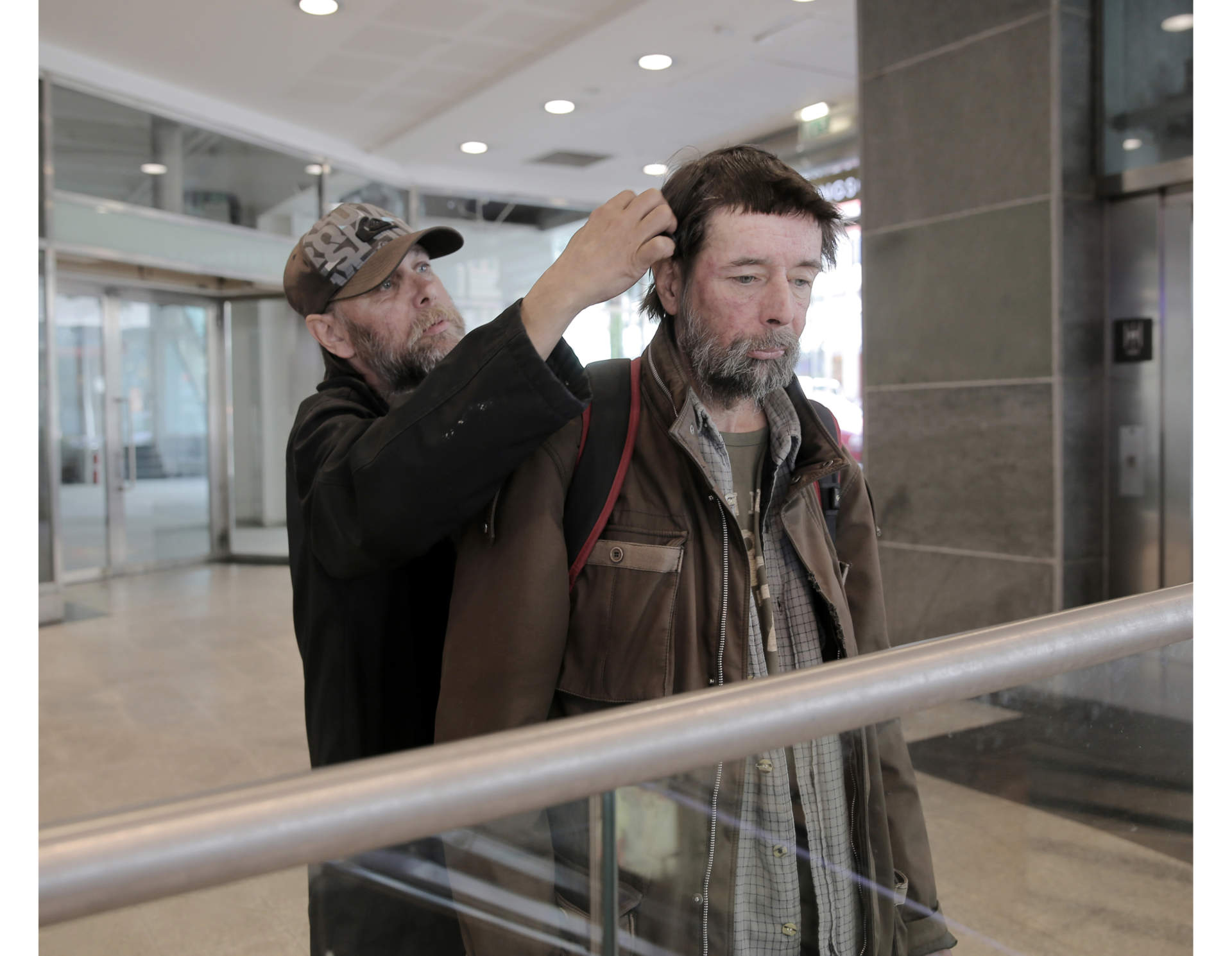 Pekka giving a helping hand to Matte, combing his hair in the morning before they go and beg for money on the street.